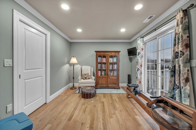 sitting room with light wood-type flooring and ornamental molding