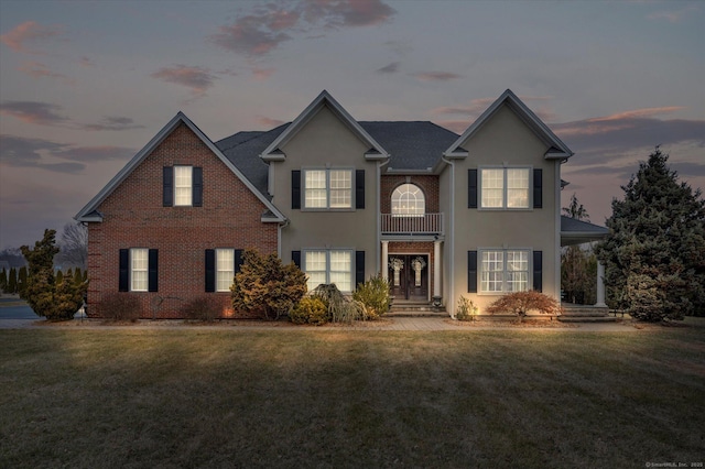 view of property featuring a lawn and a balcony