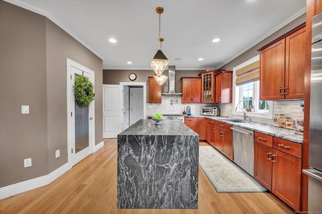 kitchen with appliances with stainless steel finishes, wall chimney exhaust hood, dark stone countertops, and a center island