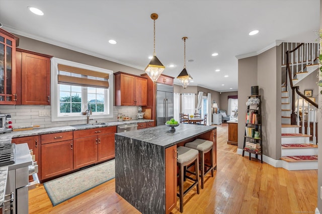 kitchen featuring ornamental molding, sink, a center island, and stainless steel appliances