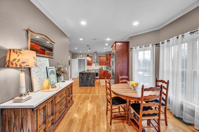 dining room featuring crown molding and light hardwood / wood-style flooring