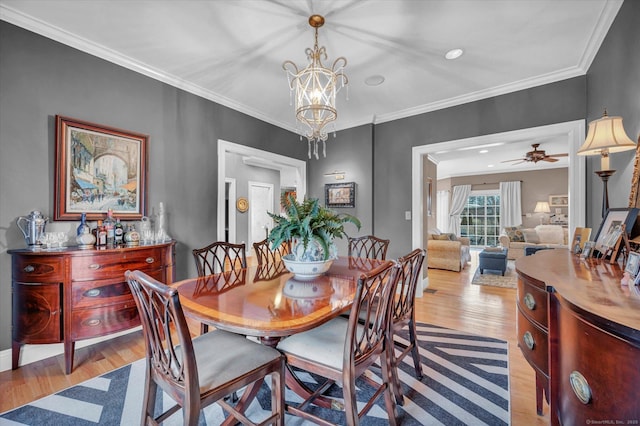 dining space with crown molding, ceiling fan with notable chandelier, and light hardwood / wood-style flooring