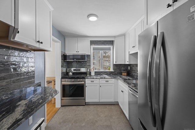 kitchen featuring stainless steel appliances, dark stone counters, and white cabinets