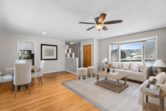 living room featuring ceiling fan and light hardwood / wood-style floors