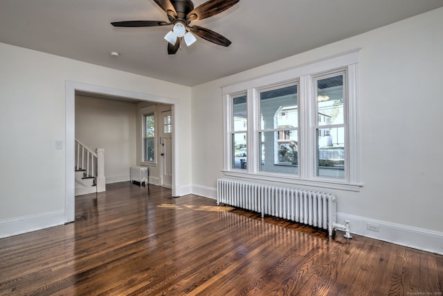 unfurnished room featuring ceiling fan, dark hardwood / wood-style flooring, and radiator heating unit