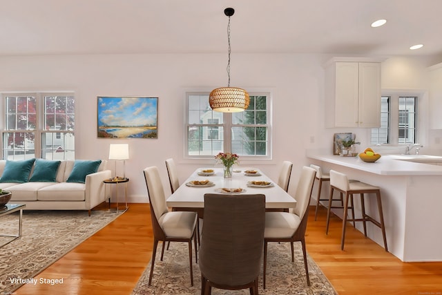 dining room with sink and light hardwood / wood-style flooring