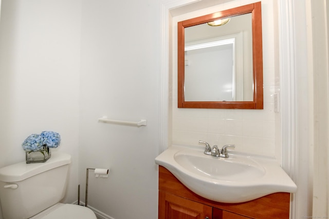 bathroom with vanity, tasteful backsplash, and toilet