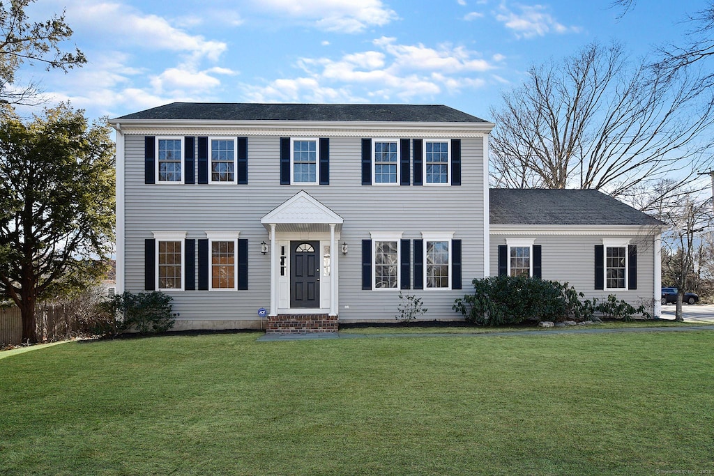 colonial home with a front lawn