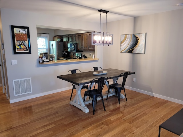 dining area featuring an inviting chandelier and wood-type flooring