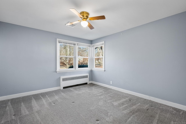 carpeted spare room featuring ceiling fan and radiator