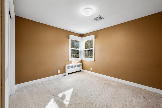 carpeted empty room with radiator heating unit