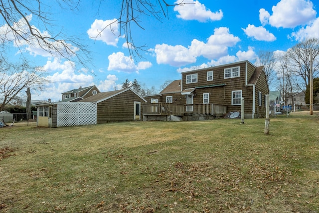 rear view of property featuring a yard and a wooden deck