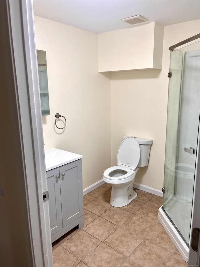 bathroom featuring a shower with door, tile patterned floors, vanity, and toilet