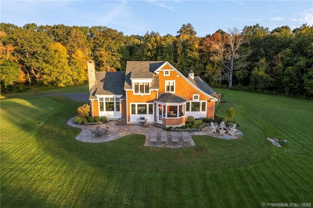 view of front of house with a front lawn, a patio area, and a sunroom