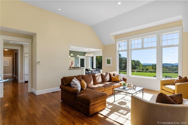 living room featuring dark hardwood / wood-style flooring, lofted ceiling, and a chandelier