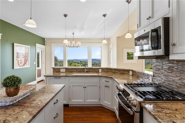 kitchen featuring white cabinets, pendant lighting, appliances with stainless steel finishes, and sink