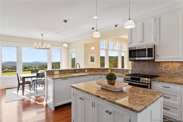 kitchen featuring appliances with stainless steel finishes, a mountain view, hanging light fixtures, and a center island