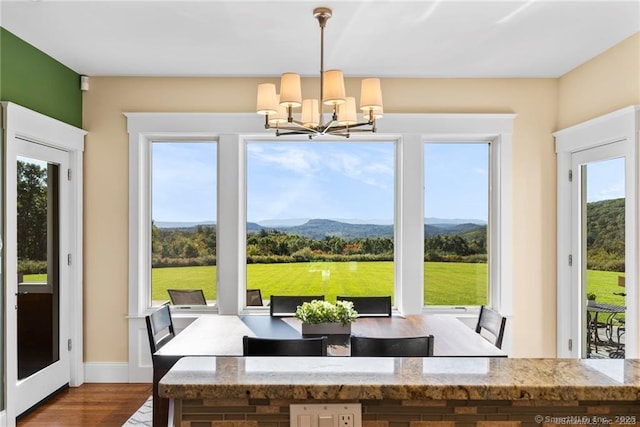 interior space featuring a mountain view, wood-type flooring, and a notable chandelier