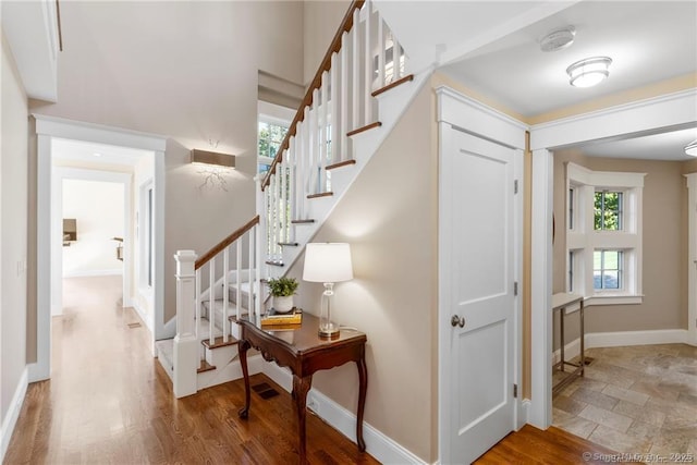 stairs with hardwood / wood-style flooring and plenty of natural light