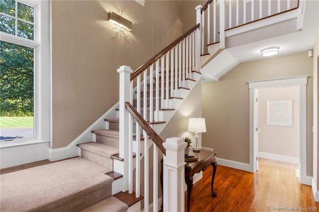 stairway featuring a wealth of natural light and hardwood / wood-style floors