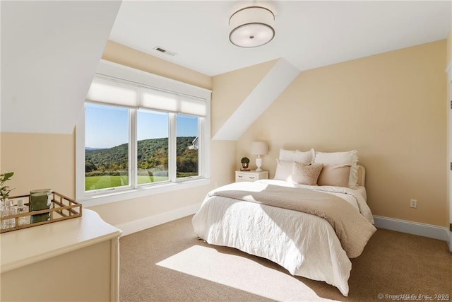 bedroom featuring a mountain view, vaulted ceiling, and carpet flooring