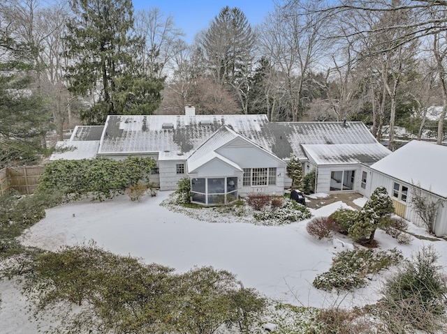 snow covered property featuring a sunroom