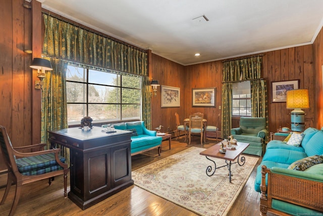 living room featuring crown molding, wood-type flooring, and wood walls