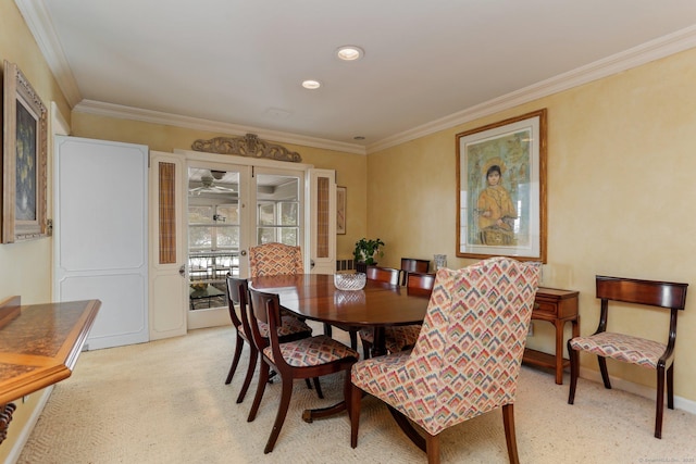 dining area featuring ornamental molding and light colored carpet