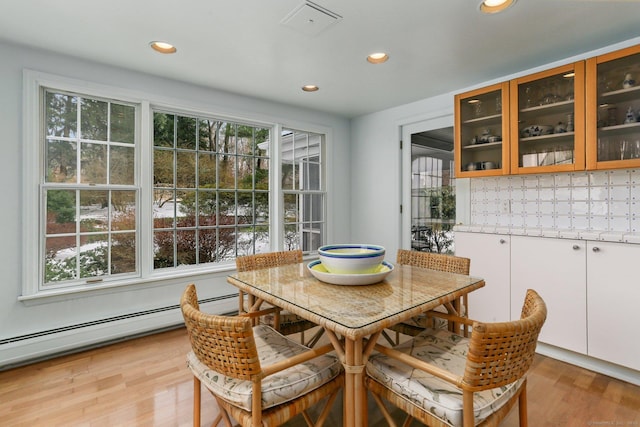 dining space with baseboard heating, a wealth of natural light, and light wood-type flooring