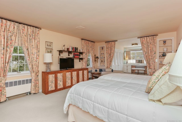 bedroom featuring multiple windows, radiator, and carpet