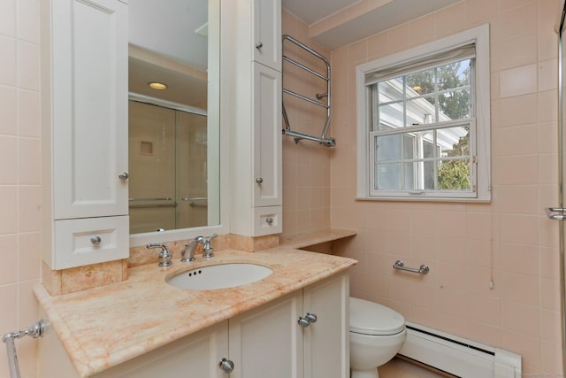 bathroom featuring tile walls, vanity, a baseboard heating unit, an enclosed shower, and toilet