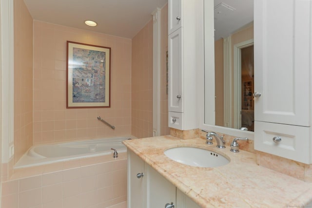 bathroom with a relaxing tiled tub and vanity