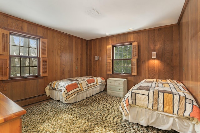 carpeted bedroom with baseboard heating and wood walls