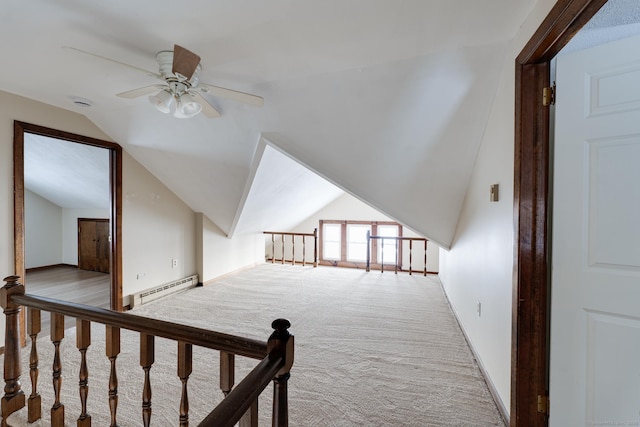 additional living space featuring baseboard heating, ceiling fan, vaulted ceiling, and light carpet