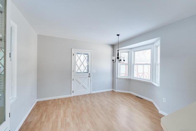 entryway featuring light hardwood / wood-style floors and a chandelier