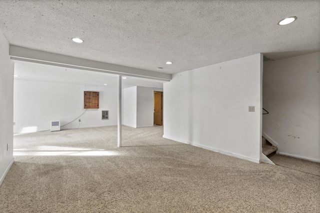 basement featuring carpet floors and a textured ceiling