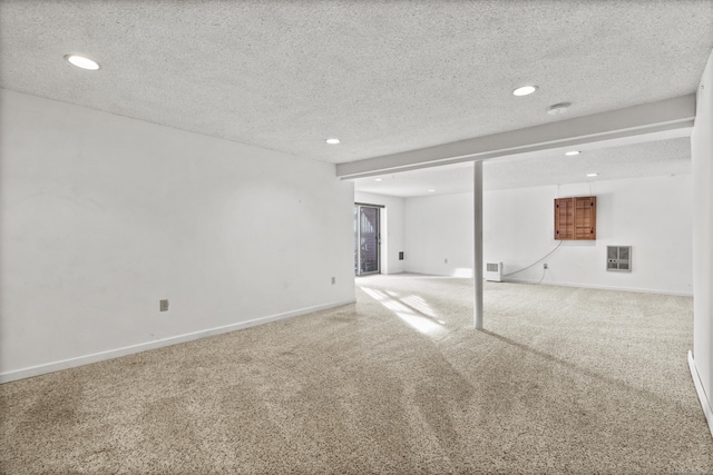 basement featuring carpet floors, heating unit, and a textured ceiling