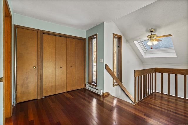 entryway featuring dark wood-type flooring, a baseboard radiator, and lofted ceiling with skylight