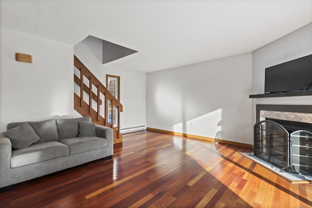 living room with a baseboard heating unit, a fireplace, and dark hardwood / wood-style floors