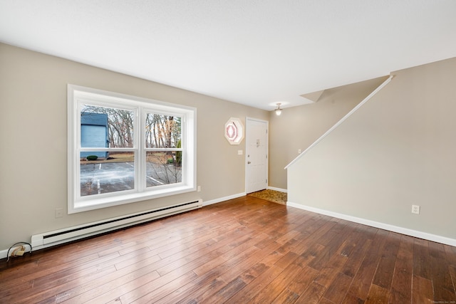 foyer entrance featuring wood-type flooring and a baseboard heating unit