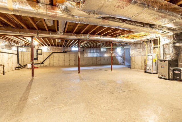 below grade area featuring heating unit, electric panel, and gas water heater