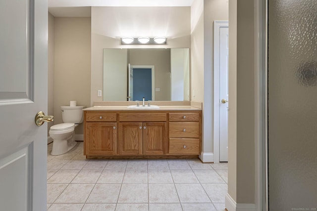 bathroom featuring vanity, toilet, baseboards, and tile patterned floors