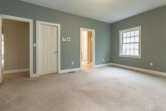 unfurnished bedroom featuring light carpet, baseboards, and visible vents