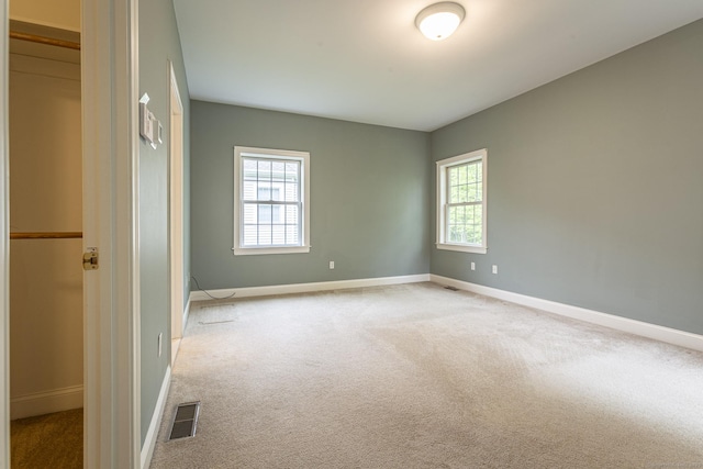 empty room with baseboards, carpet flooring, and a healthy amount of sunlight