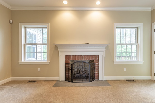 unfurnished living room with crown molding, a brick fireplace, and carpet floors