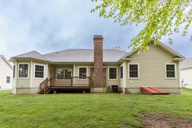 back of property featuring a wooden deck, a chimney, a lawn, and central AC