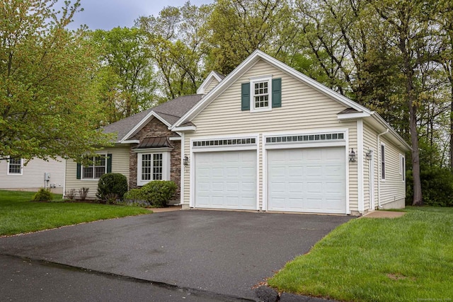 view of front of property with an attached garage, a front lawn, and aphalt driveway
