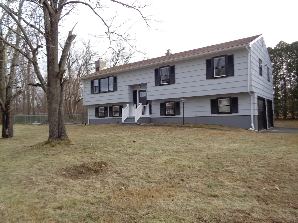 bi-level home with a garage and a front lawn