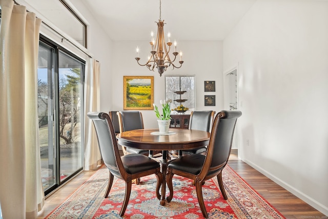 dining area with light wood-type flooring and an inviting chandelier