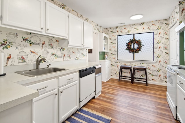 kitchen featuring sink, white appliances, white cabinets, and light wood-type flooring